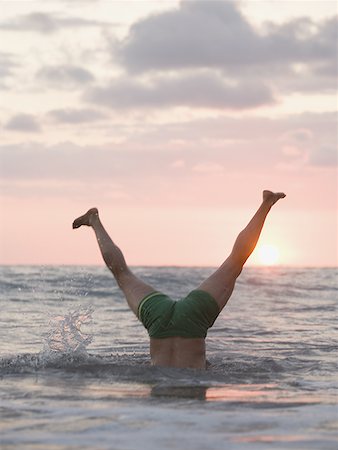 simsearch:640-01366190,k - Low section view of a mature man doing a handstand in the sea Foto de stock - Sin royalties Premium, Código: 640-01360929