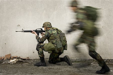 Side profile of a soldier aiming his rifle Stock Photo - Premium Royalty-Free, Code: 640-01361102