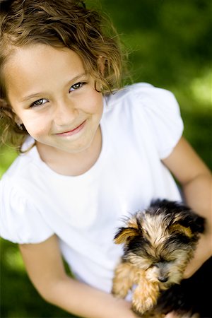 High angle view of a girl carrying a puppy Stock Photo - Premium Royalty-Free, Code: 640-01361127