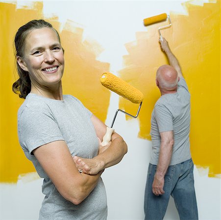 painting of old man and men - Portrait of a senior woman holding a paint roller with a senior man painting a wall Stock Photo - Premium Royalty-Free, Code: 640-01361128