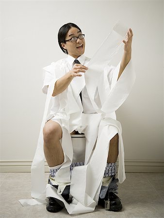 sitting on toilet - Close-up of a young man sitting on a toilet Stock Photo - Premium Royalty-Free, Code: 640-01361177