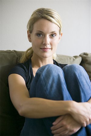 Portrait of a young woman sitting on a couch Stock Photo - Premium Royalty-Free, Code: 640-01361182