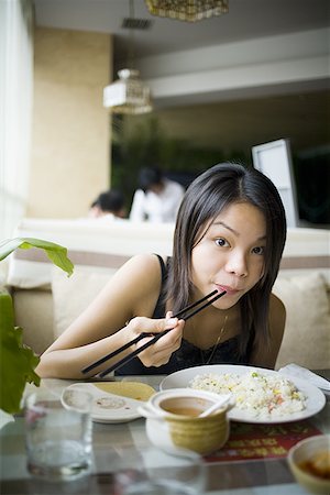 Woman eating at a Chinese food restaurant Stock Photo - Premium Royalty-Free, Code: 640-01361249