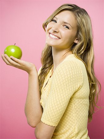 portrait of woman with fruit on head - Femme souriant avec pomme verte Photographie de stock - Premium Libres de Droits, Code: 640-01361286