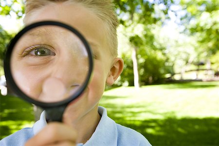 Portrait of a boy looking through a magnifying glass Stock Photo - Premium Royalty-Free, Code: 640-01361308