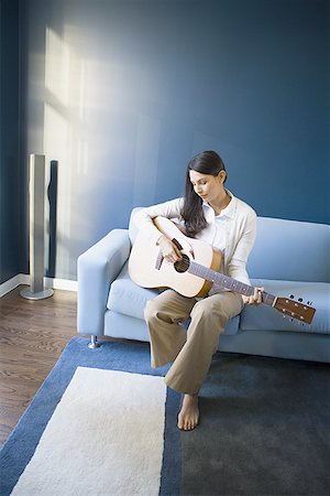 Mid adult woman playing the guitar Fotografie stock - Premium Royalty-Free, Codice: 640-01361417