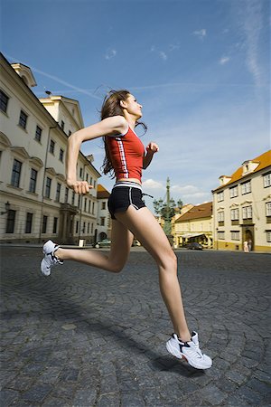 Profile of a young woman jogging Stock Photo - Premium Royalty-Free, Code: 640-01361424