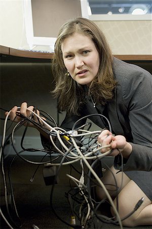 simsearch:640-01366289,k - Portrait of a businesswoman holding tangled wires Fotografie stock - Premium Royalty-Free, Codice: 640-01361425