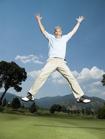 Portrait of a man jumping with his arms raised Stock Photo - Premium Royalty-Free, Code: 640-01361491