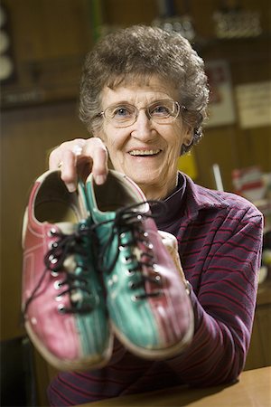 senior lady bowling photos - Portrait of a senior woman holding a pair of bowling shoes Stock Photo - Premium Royalty-Free, Code: 640-01361521