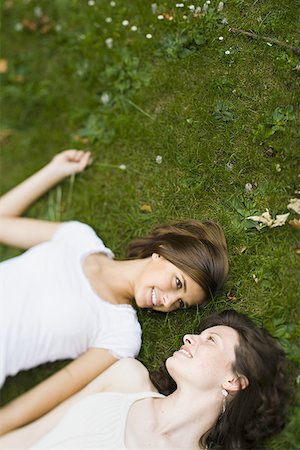 High angle view of two teenage girls lying on grass Stock Photo - Premium Royalty-Free, Code: 640-01361589