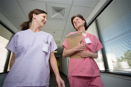 Close-up of two female nurses walking in a corridor Stock Photo - Premium Royalty-Free, Code: 640-01361582