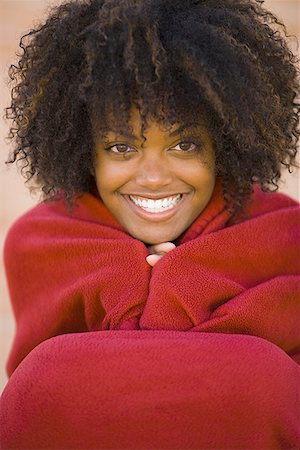 Portrait d'une jeune femme, enveloppée dans une couverture, sourire Photographie de stock - Premium Libres de Droits, Code: 640-01361609