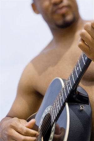 Close-up of a young man playing a guitar Stock Photo - Premium Royalty-Free, Code: 640-01361728