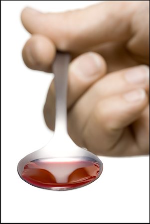 spoon with syrup - Close-up of a human hand holding a spoon of syrup Stock Photo - Premium Royalty-Free, Code: 640-01361787