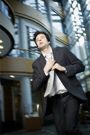 Businessman adjusting his tie Stock Photo - Premium Royalty-Free, Code: 640-01361852