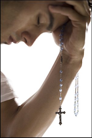 rosario - Close-up of a young man holding a crucifix Fotografie stock - Premium Royalty-Free, Codice: 640-01361916