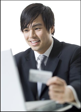 Close-up of a businessman holding a credit card and using a laptop Stock Photo - Premium Royalty-Free, Code: 640-01362014