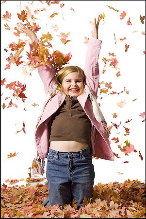 Young girl playing in fallen leaves Stock Photo - Premium Royalty-Free, Code: 640-01362042