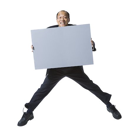 president director - Portrait of a businessman holding a blank sign and jumping Stock Photo - Premium Royalty-Free, Code: 640-01362126