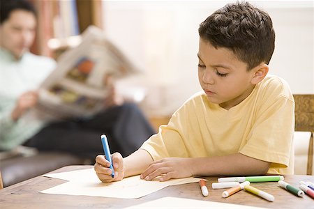Young boy coloring and drawing with father supervising Fotografie stock - Premium Royalty-Free, Codice: 640-01362154