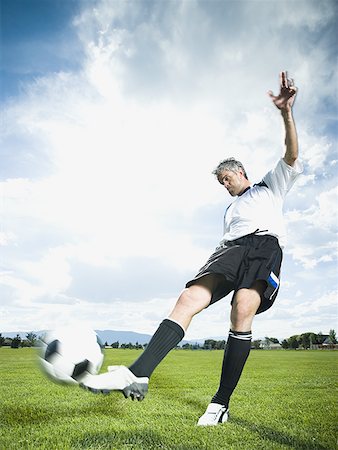 soccer player men game ball - Soccer player kicking ball Stock Photo - Premium Royalty-Free, Code: 640-01362263