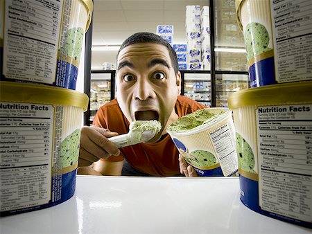 Man eating ice cream at grocery store Stock Photo - Premium Royalty-Free, Code: 640-01362278