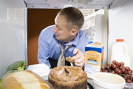 sneaking chocolate - Man in refrigerator taking icing from chocolate cake Stock Photo - Premium Royalty-Free, Code: 640-01362486