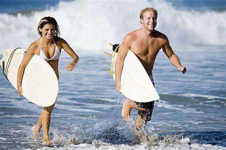 parco manuel antonio - Young couple carrying surfboards and running in water Fotografie stock - Premium Royalty-Free, Codice: 640-01362523