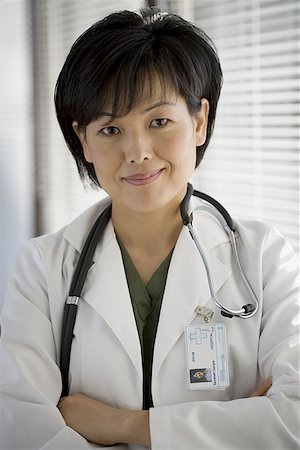 simsearch:400-05745246,k - Portrait d'une femme médecin souriant avec ses bras croisés Photographie de stock - Premium Libres de Droits, Code: 640-01362565