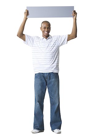 Portrait of a young African- American man holding a blank sign over his head Stock Photo - Premium Royalty-Free, Code: 640-01362580
