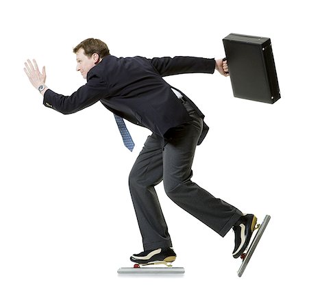 Profile of a businessman ice- skating and holding a briefcase Stock Photo - Premium Royalty-Free, Code: 640-01362602
