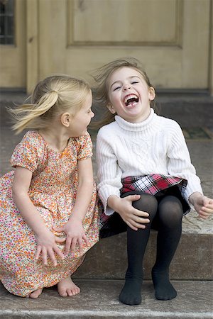 Two sisters sitting in a porch and laughing Stock Photo - Premium Royalty-Free, Code: 640-01362742
