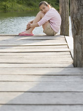 side plank pose - Portrait of a girl sitting on a pier Stock Photo - Premium Royalty-Free, Code: 640-01362773