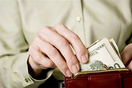 Mid section view of a woman keeping paper currency in a purse Stock Photo - Premium Royalty-Free, Code: 640-01362789