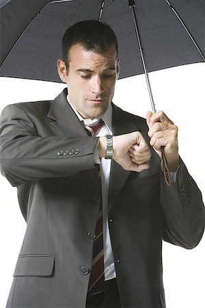 Businessman looking at his wristwatch Stock Photo - Premium Royalty-Free, Code: 640-01362783