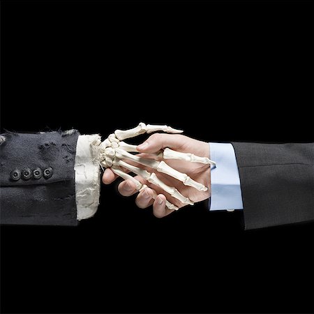 skeleton office meeting - Businessman shaking hands with skeleton Stock Photo - Premium Royalty-Free, Code: 640-01362858