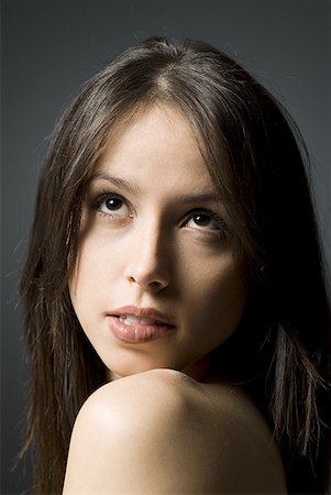 Closeup of woman looking up biting lip Stock Photo - Premium Royalty-Free, Code: 640-01362933