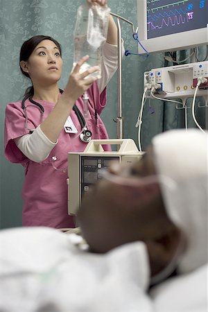 sinais vitais - Female nurse checking an intravenous drip Foto de stock - Royalty Free Premium, Número: 640-01362980