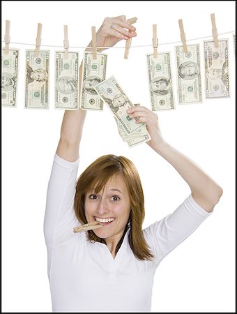 Portrait of a young woman drying dollar bills on a clothesline Stock Photo - Premium Royalty-Free, Code: 640-01363007