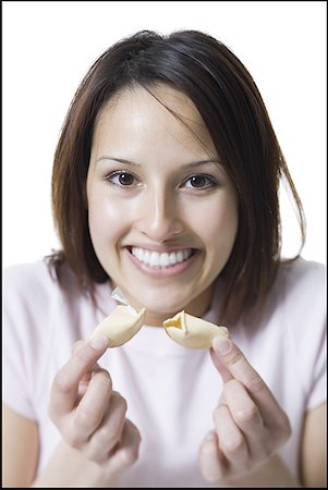 Portrait of a young woman holding fortune cookie Foto de stock - Royalty Free Premium, Número: 640-01363095