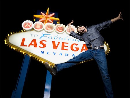 Low angle view of a young man jumping in front of a welcome sign,Las Vegas,Nevada,USA Stock Photo - Premium Royalty-Free, Code: 640-01363380