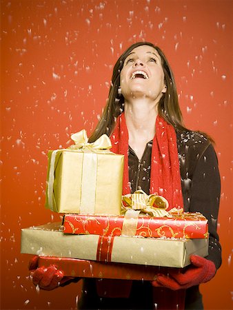 red scarf woman - Woman with Christmas gifts looking up at snow Stock Photo - Premium Royalty-Free, Code: 640-01363430