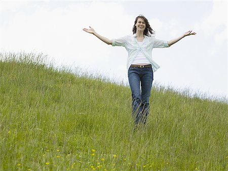 woman with her arms outstretched in a field Stock Photo - Premium Royalty-Free, Code: 640-01363440