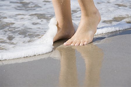 simsearch:640-01353510,k - Low section view of a young woman standing in water on the beach Fotografie stock - Premium Royalty-Free, Codice: 640-01363468