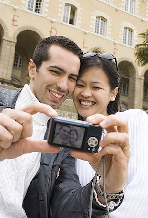 digital camera screen - Low angle view of a young couple taking a photograph of themselves Stock Photo - Premium Royalty-Free, Code: 640-01363463