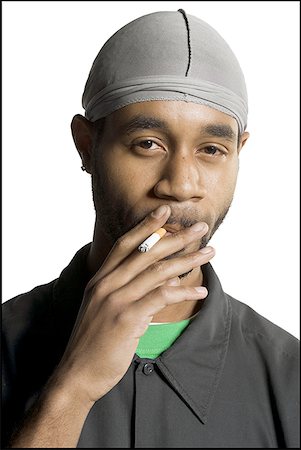 smoke in front of black - Portrait of a young man smoking a cigarette Stock Photo - Premium Royalty-Free, Code: 640-01363499