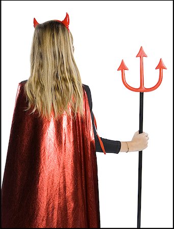 Rear view of a teenage girl wearing a devil costume holding a pitchfork Stock Photo - Premium Royalty-Free, Code: 640-01363566