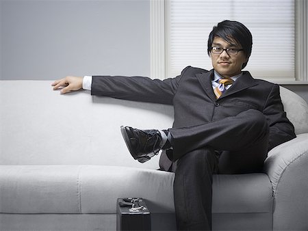 Portrait of a businessman sitting on a couch Stock Photo - Premium Royalty-Free, Code: 640-01363699