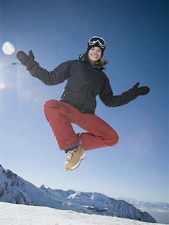 Low angle view of a young woman jumping Stock Photo - Premium Royalty-Free, Code: 640-01363725